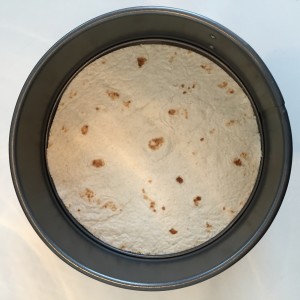 Tortilla at the bottom of the pan, ready for topping.